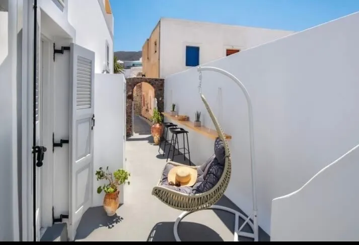 Junior Suite — private courtyard with hanging chair, Aetheria Villas, Oia, Santorini